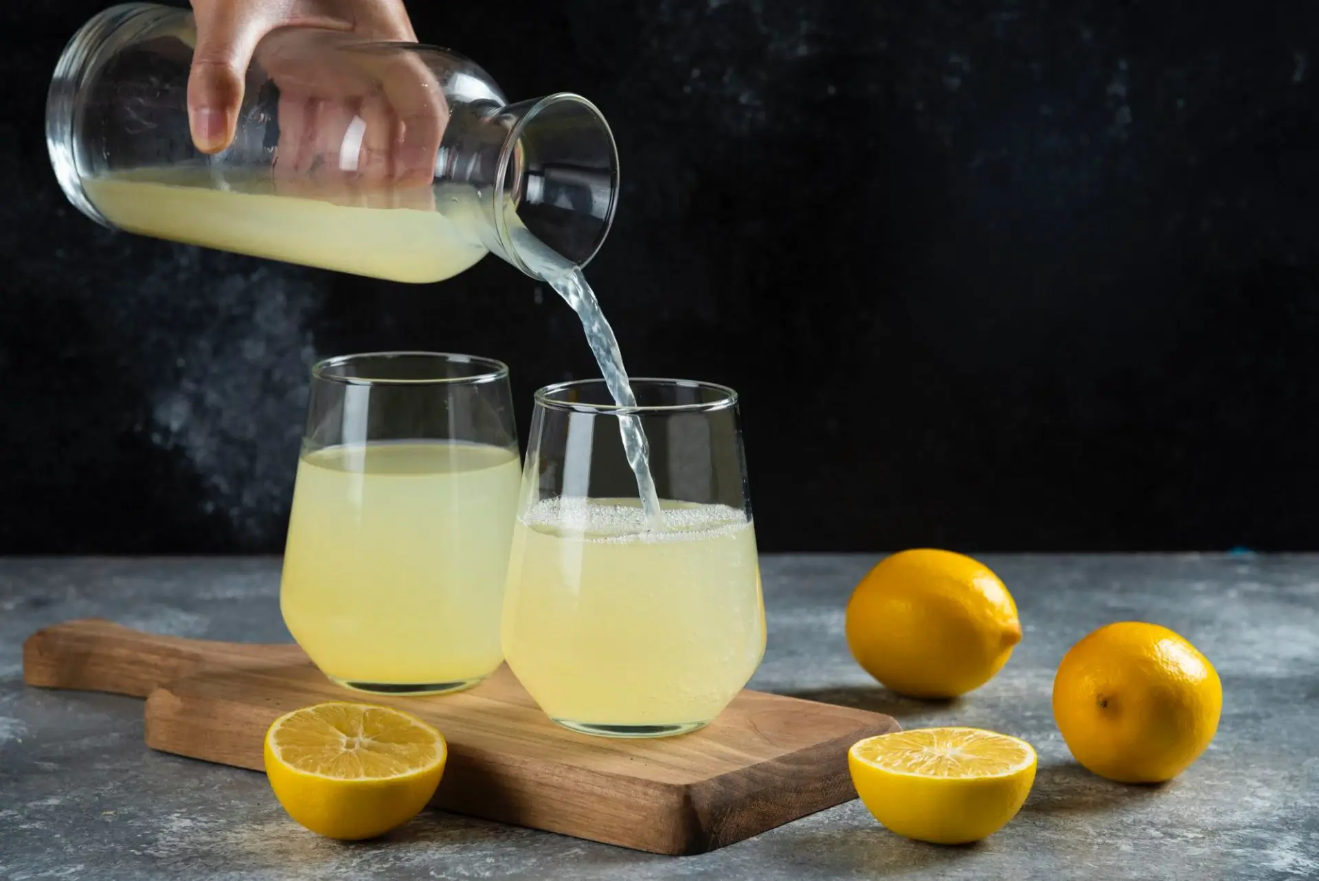 Pouring lemon juice into glass.